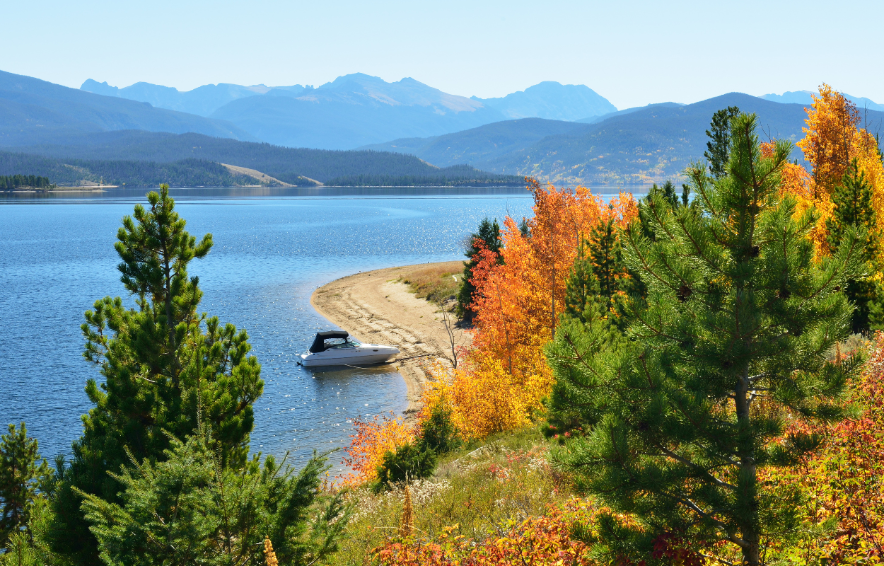 lake granby in fall with yellow trees and mountains in the background